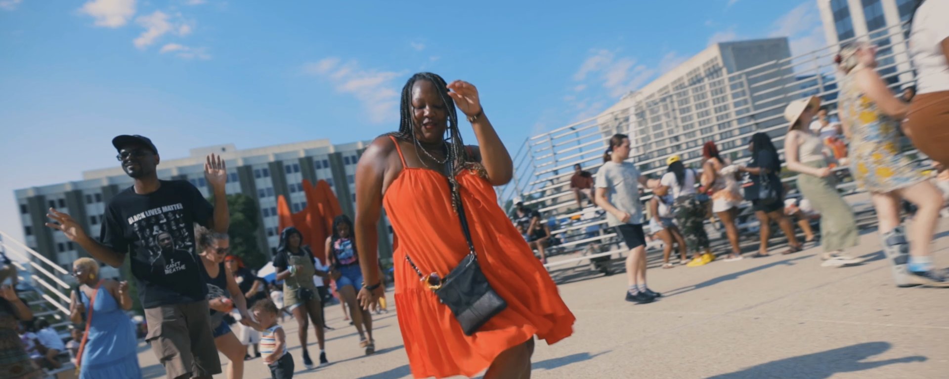 A dancer in an orange dress at Grand Rapids' Juneteenth Jam, filmed by Dogtown